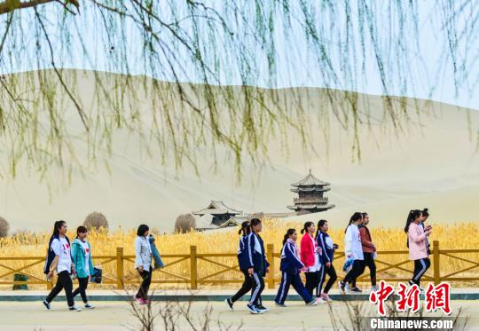 图为月牙泉畔往来不绝的游客。 王斌银 摄 图为月牙泉畔往来不绝的游客。 王斌银 摄