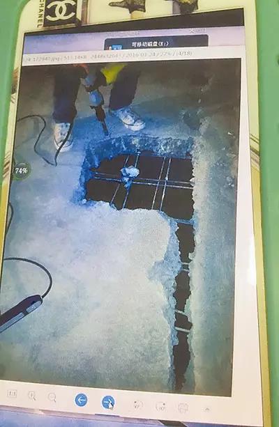 赵美玲用手机向记者展示她拍摄的照片，显示楼板只有一层钢筋。