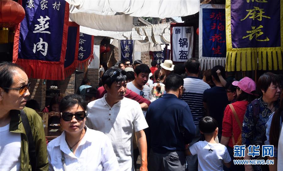 5月1日，游客在礼泉县袁家村小吃一条街游玩。
