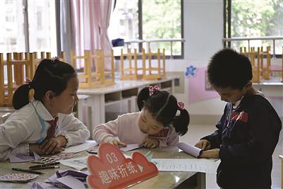 　　“小引导员（左一）”陪伴新生报名面谈。 校方供图