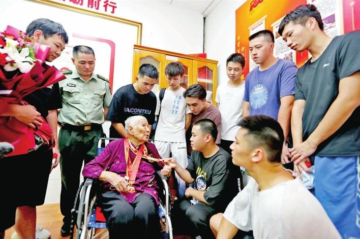 石岩应征青年围着老战士何伟聆听革命故事.jpg